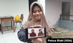 Hanan Abdullah menunjukkan siaran yang dapat diakses di kanal Youtube. (Foto: VOA/Petrus Riski)