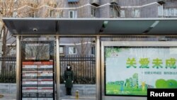 Seorang anggota Kepolisian Bersenjata Rakyat China mengenakan masker saat berjaga di jalan di tengah pandemi COVID-19 di Beijing, 1 Desember 2022. REUTERS/Thomas Peter