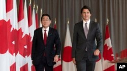Perdana Menteri Kanada Justin Trudeau (kanan) dan Perdana Menteri Jepang Fumio Kishida berjalan bersama menuju area konferensi pers di Ottawa, pada 12 Januari 2023. (Foto: Adrian Wyld/The Canadian Press via AP)