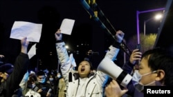 2022年11月28日,在新冠病毒疫情持续扩散之际,北京民众为乌鲁木齐火灾遇难者守夜后,举着白纸抗议中共当局的封控限制。