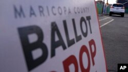 A voter casts their ballot at a secure ballot drop box at the Maricopa County Tabulation and Election Center in Phoenix, Nov. 1, 2022.