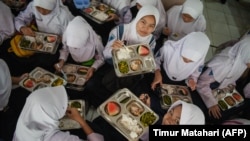 FILE - Siswa menikmati makan siang pada hari pertama program makan gratis di SMP Negeri 12 Cimahi, Jawa Barat, 6 Januari 2025. (Foto: Timur Matahari/AFP)