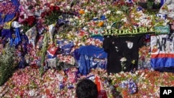 Seorang pria melempar bunga ungkapan duka di luar Stadion Kanjuruhan, di Malang, Jawa Timur, Selasa, 4 Oktober 2022, di mana lebih dari 100 orang tewas pada hari Sabtu, 1 Oktober 2022. (AP/Dicky Bisinglasi)