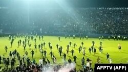 Tangkapan layar video AFPTV yang diambil pada 1 Oktober 2022 menunjukkan gas air mata yang disemprotkan di kerumunan saat suporter berlarian di lapangan setelah pertandingan sepak bola antara Arema FC dan Persebaya Surabaya di Stadion Kanjuruhan di Malang