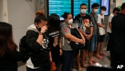 Warga Malaysia yang berhasil diselamatkan dari pedagang manusia di Kamboja tiba di Bandara Kuala Lumpur di Sepang, 6 Oktober 2022. Kasus online scam atau tipuan daring sudah menjadi masalah regional dengan korban berasal dari berbagai negara, termasuk Indonesia. (Foto: AP)