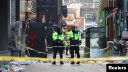 Polisi berjaga-jaga di lokasi tragedi massa berdesakan pada perayaan Halloween di distrik Itaewon yang populer di Seoul, Korea Selatan, 30 Oktober 2022. (Yonhap/Reuters) Yonhap via REUTERS