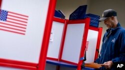FILE - McArthur Myers fills out his ballot at an early voting location in Alexandria, Va., Sept. 26, 2022.