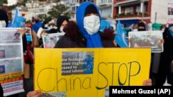 Anggota komunitas Uighur yang tinggal di Turki, menggelar demonstrasi di Istanbul, 10 Februari 2021. Investigasi Kongres AS sebut BMW, Jaguar Land Rover, dan Volkswagen menggunakan komponen dari pemasok China yang dilarang karena dugaan kerja paksa. (Foto: AP/Mehmet Guzel)