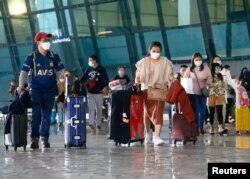Pelancong berjalan setelah mereka tiba di Bandara Soekarno-Hatta di Tangerang, di pinggiran Jakarta, 1 Januari 2021. (Photo: REUTERS/Ajeng Dinar Ulfiana)