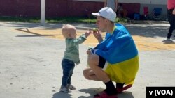A father blows bubbles with his son on April 6, 2022, at the Benito Juarez sports center in Tijuana, Mexico, that was turned into a refugee center for Ukrainians. 