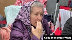 A Ukrainian refugee traveling with her daughter and granddaughters sits outside the San Ysidro port of entry in Tijuana, Mexico, on April 5, 2022. as she makes her way to another daughter already living in the U.S.