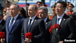 俄罗斯总统普京（中）、哈萨克斯坦总统纳扎尔巴耶夫（左）和中国国家主席习近平在莫斯科市中心无名烈士墓