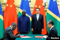 Perdana Menteri Kepulauan Solomon Manasseh Sogavare, Menteri Luar Negeri Kepulauan Solomon Jeremiah Manele, Perdana Menteri China Li Keqiang dan Penasihat Negara dan Menteri Luar Negeri China Wang Yi menghadiri upacara penandatanganan di Aula Besar Rakyat di Beijing, China, 9 Oktober 2019. (Foto: REUTERS/Thomas Peter)