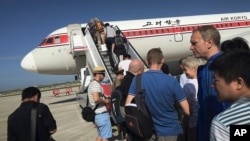 旅客在平壤国际机场登上前往北京的飞机