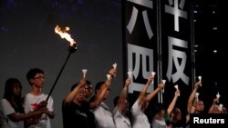 FILE - Pro-democracy activists raise up candles during a candlelight vigil to mark the 30th anniversary of the crackdown of China's pro-democracy movement at Beijing's Tiananmen Square in 1989, at Victoria Park in Hong Kong, June 4, 2019.