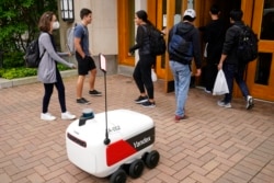 Robot pengantar makanan berhenti di luar sebuah gedung di Ann Arbor, Michigan pada Kamis, 7 Oktober 2021. (Foto: AP)