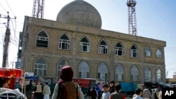 Seorang anggota pasukan Taliban berjaga di luar masjid yang menjadi lokasi pengeboman di provinsi Mazar-e-Sharif, Afghanistan, pada 21 April 2022. (Foto: AP)