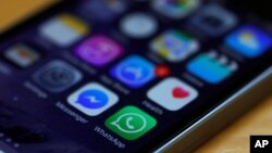ARSIP - Ikon WhatsApp dan Facebook Messenger tampak dalam sebuah iPhone di Manchester, Inggris, 27 Maret 2017 (foto: Reuters/Phil Noble)