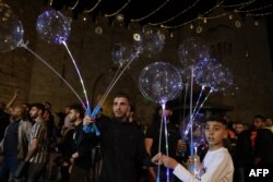 Warga Palestina menjual balon di luar gerbang Damaskus di Kota Tua Yerusalem, pada hari pertama bulan suci Ramadan, 2 April 2022. (Foto: Menahem KAHANA / AFP)