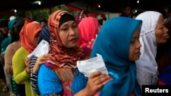 Villagers line up to vote in the country's presidential election at Bojong Koneng polling station in Bogor, Indonesia, July 9, 2014.