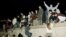FILE - East German citizens climb the Berlin wall at the Brandenburg Gate as they celebrate the opening of the East German border.