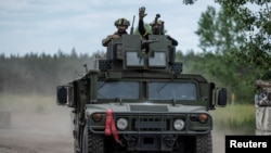 乌克兰部队的装甲车在俄乌边界附近的沃夫昌斯克镇（Vovchansk）行进。