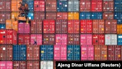 Seorang pekerja berjalan di atas tumpukan peti kemas di Pelabuhan Tanjung Priok, Jakarta, 22 Januari 2021. (Foto: REUTERS/Ajeng Dinar Ulfiana)