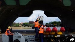 资料照片：在台湾东南部花莲空军基地的台湾军事人员准备将鱼叉反舰导弹装载到F-16V战机上。(2022年8月17日）