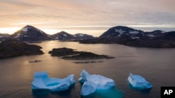 Gunung es besar mengapung saat matahari terbit di dekat Kulusuk, Greenland, 16 Agustus 2019. (Foto: AP)