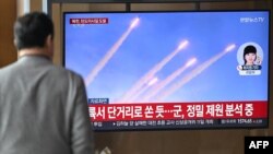 ຊາຍຄົນນຶ່ງເບິ່ງໂທລະພາບ ຂະນະທີ່ລາຍງານຂ່າວ ກ່ຽວກັບການຍິງທົດລອງລູກສອນໄຟຂີປະນາວຸດຂອງເກົາຫຼີເໜືອ, ຢູ່ສະຖານີລົດໄຟ ໃນນະຄອນຫຼວງໂຊລ, ວັນທີ 10 ມີນາ 2025.