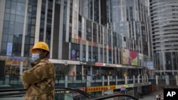 一名身穿工装的工人乘坐电梯到达北京一个空荡荡的商贸区。(2023年1月11日)