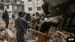 Polisi berpakaian preman berkumpul di atas puing-puing masjid yang rusak setelah ledakan bunuh diri pada 30 Januari di Peshawar pada 1 Februari 2023. (Foto: AFP)