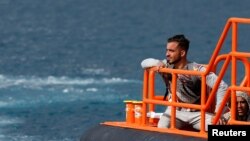 Migran menunggu turun dari kapal penjaga pantai Spanyol, di pelabuhan Arguineguin, di pulau Gran Canaria, Spanyol, 4 Februari 2023. (REUTERS/Borja Suarez)
