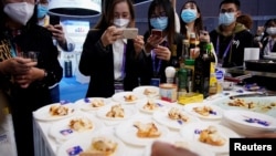 Para pengunjung mengabadikan foto lobster Austrial saat pameran internasional di Shanghai, China, 6 November 2020. (Foto: Aly Song/Reuters)