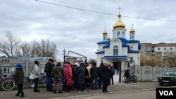 2022年4月6日，博罗江卡居民在教堂附近等候领取人道救援物资。(美国之音希瑟·默多克拍摄)
