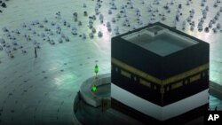 Muslimanski hodočasnici mole se izpred Ćabe, kockaste građevine u Velikoj džamiji, dok nose maske, na početku godišnjeg hodočašća hadž u Meki, Saudijska Arabija, 18. jula 2021.