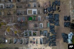 Policemen work to identify civilians who were killed during the Russian occupation in Bucha, Ukraine, on the outskirts of Kyiv, April 6, 2022.