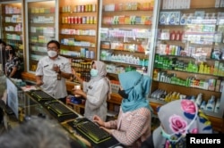 Petugas kesehatan memeriksa sirup obat yang mengandung Êetilen glikol dan dietilen glikol di apotek di Bandung, provinsi Jawa Barat, 26 Oktober 2022. (Antara Foto/Raisan Al Farisi/via REUTERS)