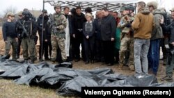 ប្រធាន​គណៈកម្មការ​សហភាព​អឺរ៉ុប​លោកស្រី Ursula von der Leyen និង​គណៈប្រតិភូ​ឈរ​នៅ​ក្បែរ​រណ្តៅ​សាកសព​មួយ​កន្លែង​​​ក្នុង​ពេល​ទៅ​ទស្សនា​ទី​ក្រុង Bucha ជាយ​រដ្ឋធានី​កៀវ​ប្រទេស​អ៊ុយក្រែន កាល​ពី​ថ្ងៃ​ទី៨ ខែ​មេសា ឆ្នាំ​២០២២។ (Reuters)