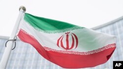 Bendera Iran berkibar di depan gedung Pusat Internasional yang juga merupakan markas Badan Tenaga Atom Internasional (IAEA), di Wina, Austria, pada 24 Mei 2021. (Foto: AP/Florian Schroetter)
