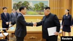 朝鲜领导人金正恩(中右)与到访的韩国特使、国家安全办公室负责人郑义荣握手。(2018年3月5日)