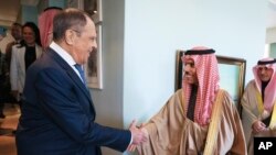 Menteri Luar Negeri Rusia Sergey Lavrov (kiri) menjabat tangan Menteri Luar Negeri Arab Saudi Pangeran Faisal bin Farhan Al-Saud dalam pertemuan di sela konferensi anggota BRICS di Cape Town, pada 1 Juni 2023. (Foto: Russian Foreign Ministry Press Service via AP)