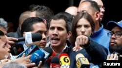 Pemimpin oposisi Venezuela dan presiden interim, Juan Guaido, ditemani oleh istrinya Fabiana Rosales, berbicara kepada media setelah acara kebaktian di gereja di Caracas, Venezuela, 27 Januari 2019 (foto: Reuters/Carlos Garcia Rawlins)