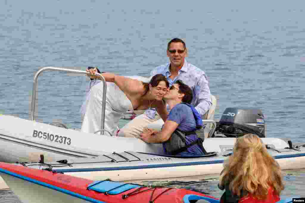Newlyweds Michelle and Heiner Gruetzner, who were holding their wedding reception nearby, meet Canada's Prime Minister Justin Trudeau while he was kayaking off Sidney, British Columbia, Canada, Aug. 5, 2017.