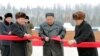Pemimpin Korea Utara Kim Jong Un didampingi oleh Pak Pong Ju, wakil ketua Komisi Urusan Negara DPRK, memotong pita saat upacara di Kabupaten Samjiyon, Korea Utara, pada 2 Desmeber 2019. (Foto: KCNA via Reuters)