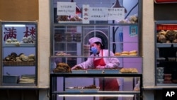 Seorang chef sedang menyiapkan sejumlah makanan di sebuah restoran di Beijing, China, 22 Februari 2020. (Foto: Ng Han Guan/AP Photo)