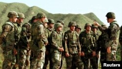 Marinir AS berkumpul bersama saat mereka mendengarkan instruksi atasan mereka selama latihan menembak langsung di Kamp militer Amerika Hansen di Pulau Okinawa, 6 Maret (Foto: Reuters)