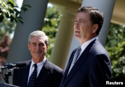 FILE - James Comey, right, speaks alongside outgoing FBI Director Robert Mueller in the Rose Garden of the White House in Washington, June 21, 2013.