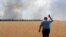 A farmer reacts as he looks at his burning field caused by the fighting at the front line in the Dnipropetrovsk region, Ukraine, Monday, July 4, 2022. (Efrem Lukatsky/AP)