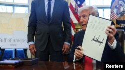 2025년 2월 25일 워싱턴 D.C. 백악관 오벌 오피스에서 도널드 트럼프 미국 대통령이 서명한 행정 명령 문서를 들어보이고 있다.